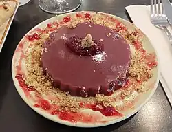 Pelamoushi, un dessert géorgien en forme de gelée violette au goût de raisin, saupoudré légèrement de noix concassées et de gelée