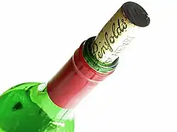 Photo en couleurs en gros plan du goulot d'une bouteille de vin et de son bouchon en liège.