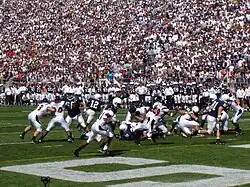 Un match de football américain se dispute devant une foule nombreuse.
