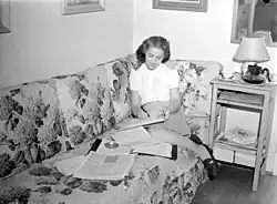 Cécile Chabot écrit assise sur un divan de sa résidence située avenue de l'Esplanade à Montréal, en 1945.