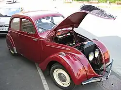 202 capot ouvert, découvrant sa caisse à outils, son moteur, son radiateur et ses phares.