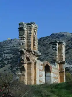deux piliers massifs reliés par un mur percé d'une porte
