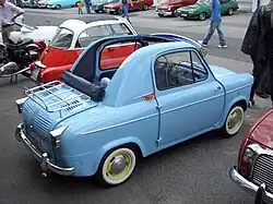 Photographie de l'arrière d'une petite voiture bleue décapotable.