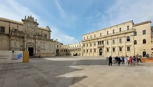 La place de jour avec sur la gauche la façade nord de la cathédrale, au centre le palais épiscopal et à droite le palais du Séminaire.