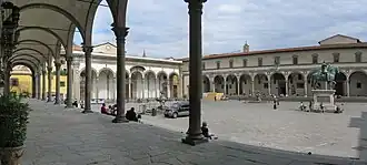 Place entourée de colonnades avec une statue équestre au centre