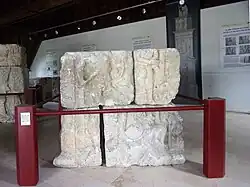 Photographie en couleurs d'un assemblage de blocs sculptés représentant des personnages.