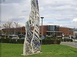 Une sculputre et la piscine Aqualia en arrière-plan.