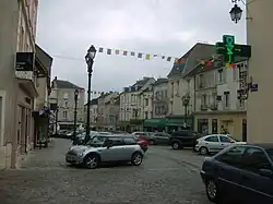 Photographie de la place du marché, l'ancienne mairie était située dans le premier bâtiment à gauche.
