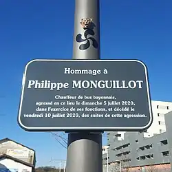 Photographie en couleurs représentant un panneau (la note détaille le média).