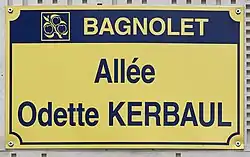 Photo d'une plaque de rue portant la mention « Allée Odette Kerbaul » sur fond jaune.