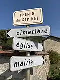 Trois panneaux D29b sous une plaque de rue E60.
