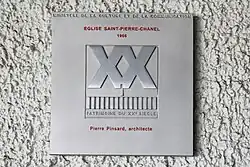 Plaque posée sur un mur sur laquelle est écrit "Label XXe siècle"