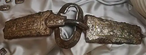 Photographie d'une plaque et d'une boucle de ceinture retrouvée dans la sépulture féminine no&nbsp;590, et actuellement conservée au Musée Saint-Loup, à Troyes.