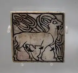 Plaque d'incrustation carrée (3&nbsp;×&nbsp;3&nbsp;cm) en nacre gravée, représentant une gazelle. DA IIIA, Ur. British Museum.