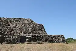 extrémité est du cairn. La partie couverte du couloir est murée.