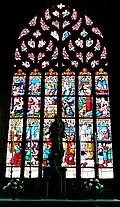 Église paroissiale : vitrail derrière le maître-autel racontant la vie de saint Yves