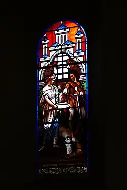 Photographie couleur d'un vitrail montrant la tête de Jean-Baptiste offerte sur un plat.