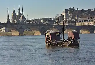 L'obélisque du pont tel qu'aligné avec les flèches de l'église Saint-Nicolas, et les arches avec les aubes d'une toue cabanée.