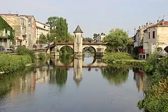 Photographie d'une rivière avec un pont en arrière-plan.