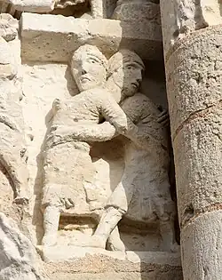 Deux personnages qui s'embrassent ou qui luttent. Façade ouest.