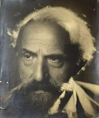 Portrait en noir et blanc d'un homme portant une barbe et une moustache.