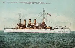 Photo colorisée d'un cuirassé blanc vu de profil.