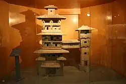 Maquette en céramique peinte de la moitié de la période des han orientaux représentant deux tours résidentielles rejointes par un pont couvert.