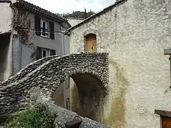 Pounti passant au-dessus d’une ruelle.