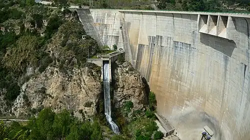 Photo montrant la partie du barrage côté ouest, sur El Pinar. Les déversoirs près du sommet sont sur Lecrín, la chute d'eau au centre est sur El Pinar