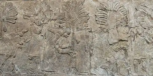 Des prisonniers sont conduits à travers des palmeraies en direction du quartier général assyrien.