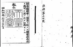 Photo noir et blanc d'un sceau impérial sur un texte de loi écrit en japonais, noir sur fond blanc.