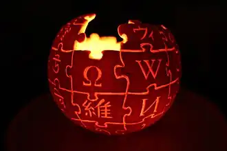 Logo de Wikipédia reproduit sur une citrouille et illuminé de l'intérieur.