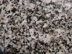 Photo d'un minéral blanc tacheté de noir