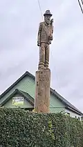 Bucheron sculpté, devant une entreprise forestière.