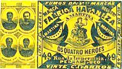 Lithographie en noir sur fond jaune. À gauche, quatre portraits d'homme en médaillon. À droite, l'étiquette commerciale de la marque "Fabrica havaneza", avec en sous-titre "Os quatro heroes" (les quatre héros).