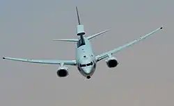 Photographie d'un avion bi-moteur en vol, vu de face.