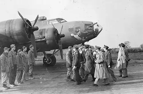 Le roi George VI passe devant un B-17 Flying Fortress (numéro de série AAF 41-24352) surnommé « Holey Joe » alors qu’il rencontre le personnel du 301st Bomb Group lors d’une visite royale à Chelveston le 14 novembre 1942.
