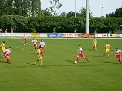Photographie représentant les joueurs du Racing Club Fléchois en rouge et blanc lors d'une rencontre de championnat au stade Montréal.
