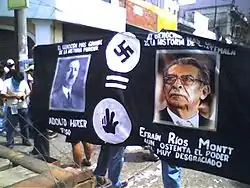 Manifestation étudiante de 2006 à la ville de Guatemala. La photo montre des étudiants portant une banderole comparant Efraín Ríos Montt à Adolf Hitler.