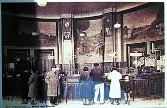 Raoul Brandon devant les guichets de l'hôtel des Postes de Chartres et les peintures murales de Pierre Vaillante