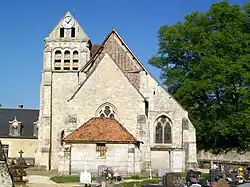L'église avec son clocher roman, vue depuis le cimetière à l'est.