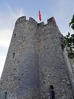 Photographie en couleurs d'une tour cylindrique accolée à une autre carrée.