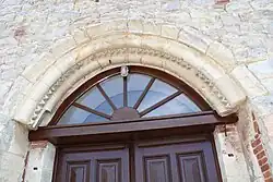 La porte moulurée en plein cintre qui date du XIIe&nbsp;siècle est la partie la plus ancienne de l'église.