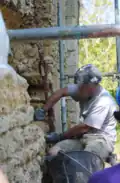 Un maçon fait une démonstration lors de la restauration de la muraille.