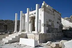 Vue générale d'un édifice antique à colonnade avec nombreuses pierres récentes de couleur différente