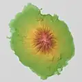 Carte en couleur du relief d'un île avec, en son centre, un volcan. La plaine est représentée en vert, les hauteurs de jaune à orange foncé, et la mer en gris.