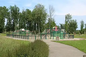 Aire de jeux multisports entourée de barrières en bois.