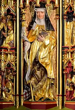 Moniale portant un livre, dont la tenue est rehaussée d'or, dans un décors baroque.