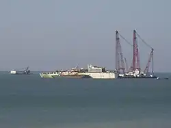 Vue du chantier de démolition le 18 avril 2007. À gauche la barge-grue Missing Link, à droite la Rambiz, et amarré au Rokia Delmas un petit cargo chargé d'évacuer sa cargaison.