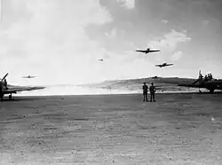 Photo noir et blanc d'avions décollant d'une piste en terre